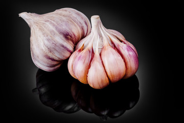 Fresh garlic bulbs on a black background.