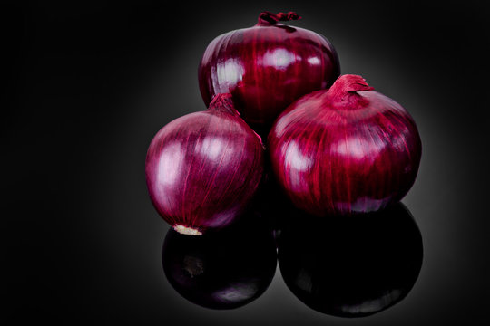 Shallots on black background with reflect onion bulb.
