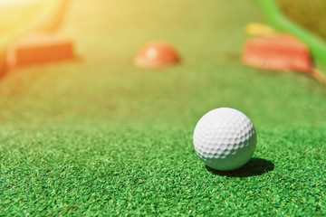 Mini-golf ball on artificial grass. Summertime.