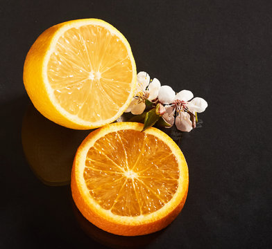Delicious and juicy orange and lemon isolated on a black background.