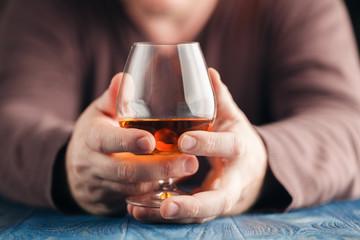 Man abusing alcohol for relaxing, whisky in glass