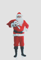Real Santa Claus carrying big bag full of gifts, isolated on white background