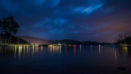 Сolorful lights of yachts on the night coast. Turkey