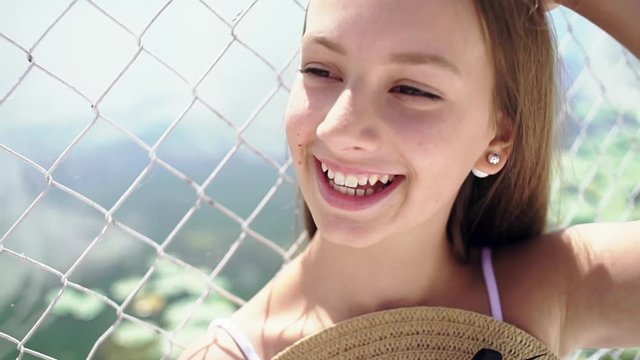 Cute, beautiful girl in the summer bonnet on a warm, warm day