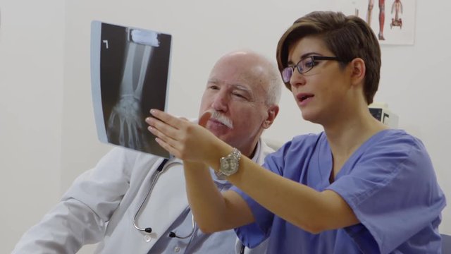Nurse and elderly doctor discussing x-rays
