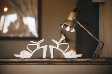 White bridal shoes on wooden table