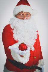 Real Santa Claus holding christmas ball, isolated on white background