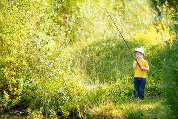 Little boy is engaged in fishing in a pond. Child with a dairy in his hands.