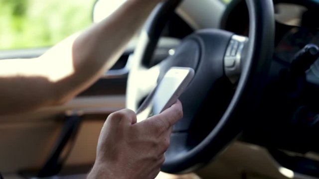 Man Uses His Smartphone While Driving, Slow Motion Closeup