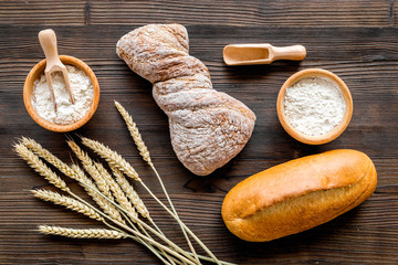 baking bread with wheat flour and ears on table rystic background top view