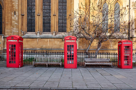 Three traditional red London telephone booths standing in front of Euston Church in Byng Place