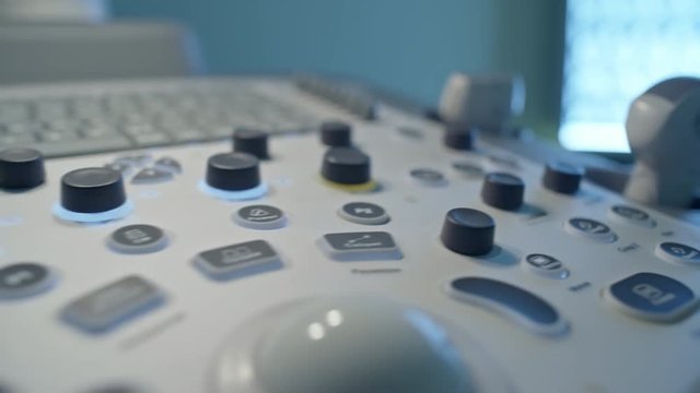 PAN with close up of keyboard and transducer tube on control panel of ultrasound machine