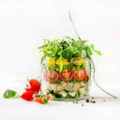 Healthy salad jar with quinoa and vegetables, cherry tomatoes, cucumber, ruccola. Raw vegetarian meal for diet, detox, clean eating. Homemade concept
