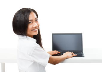 Young pretty smiling Asian woman typing on black laptop isolated