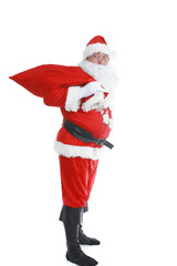 Real Santa Claus carrying big bag full of gifts, isolated on white background