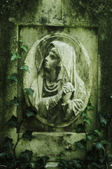 Virgin Mary statue. Vintage sculpture of sad woman in grief (Religion, faith, suffering, love concept)