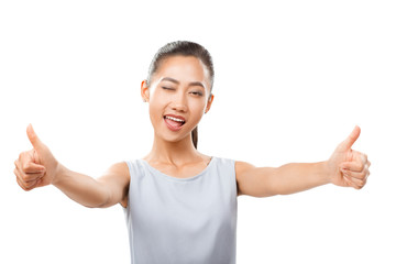 Asian woman with stretched hands showing thumbs up and winking