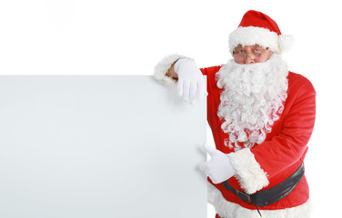 Happy Santa Claus looking out from behind the blank sign isolated on white background