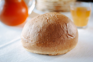 Fresh hot bread on white tablecloth at restaurant table.