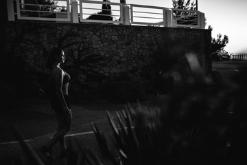 beautiful girl with sports forms sports on the beach, drinking water, jumping, running, doing different exercises