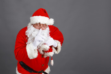 Real Santa Claus carrying big bag full of gifts, isolated on white background