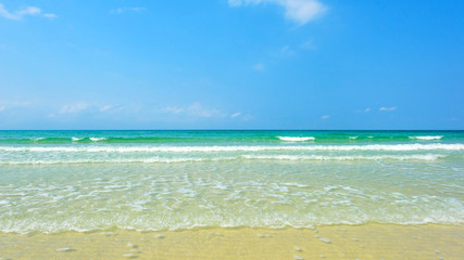 Fototapeta na wymiar Beautiful gentle wave at the shallow beach with blue sky