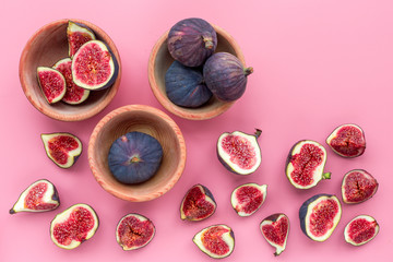 Fresh blue figs in bowls on pink background top view