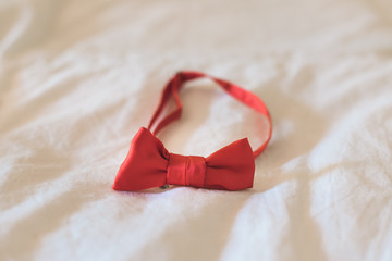 Red bow tie on a white cloth