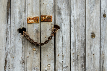 Old abandoned wood door closed with rusty chain
