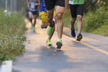 Fototapeta premium Marathon runners focus clear running shoes on the street with rain.