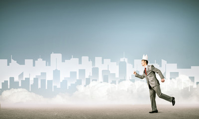 Fototapeta premium King businessman in elegant suit running and blue cityscape silh