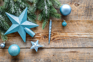 Star and balls for christmas tree near pine branches on wooden background top view copyspace