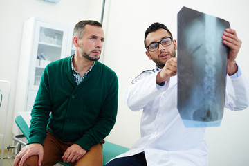 Radiologist with x-ray results explaining his patient problem with spinal cord