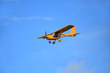 Fototapeta na wymiar Samolot awionetka ultralekki w powietrzu na błękitnym niebie.