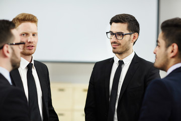 Successful leaders in formalwear having conversation at meeting after conference