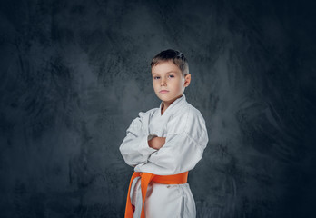 Preschooler boy dressed in a white karate kimono.