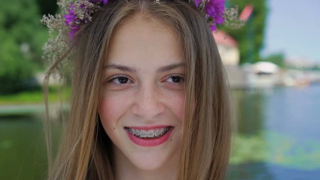 Portrait of happy female teen with braces on teeth smiling at camera. 4K