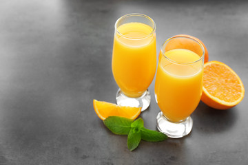 Glasses of fresh orange juice on table