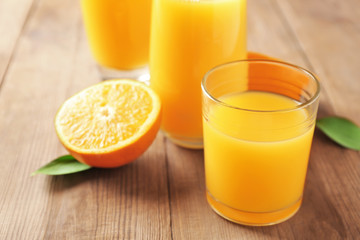 Glass of fresh orange juice on table
