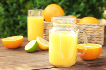 Mason jar with fresh orange juice on table