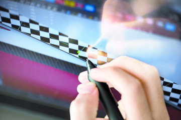 Computer graphics designer drawing with touch pen on the display