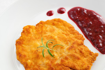 fried breaded poultry with wild berries sauce decorated with rosemary