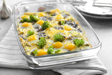 Baking dish with broccoli casserole on table