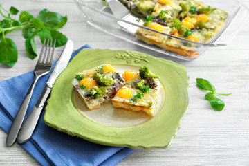 Plate with tasty broccoli casserole on wooden table