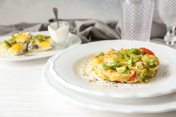 Plate with tasty broccoli casserole on wooden table