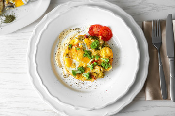 Plate with tasty broccoli casserole on wooden table