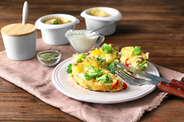 Plate with tasty broccoli casserole on wooden table
