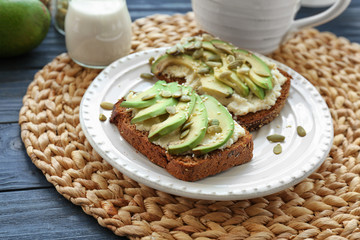 Delicious toasts with avocado and pumpkin seeds on plate