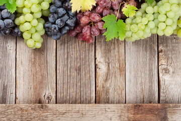 Various colorful grapes on wood