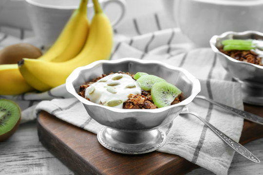 Tasty dessert with yogurt in bowl on table